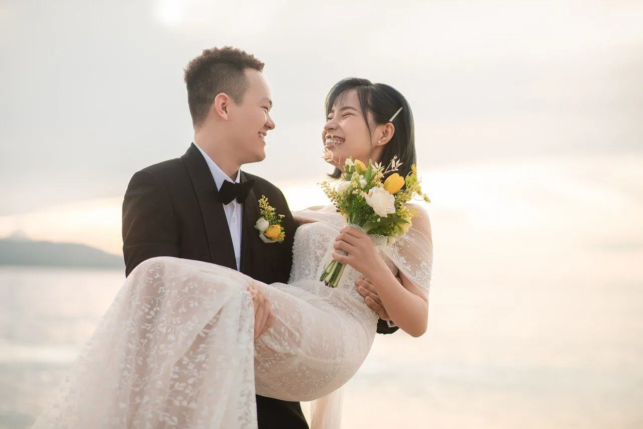 お姫様抱っこで向き合う花嫁と花婿